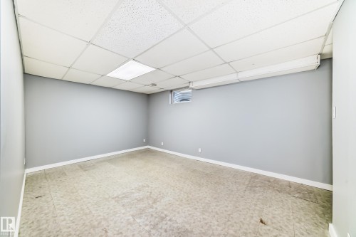 Spacious room featuring light gray walls and a drop ceiling with recessed lighting - 9D Castle Terrace, Edmonton, AB 