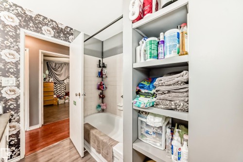 Bathroom featuring a white tub, white subway tile surround, and a coordinating shower rod - 5106 19 Avenue, Edmonton, AB 
