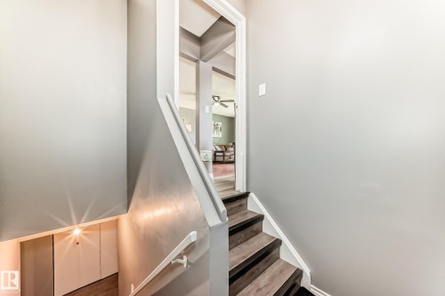 Wood-finish stairs with white risers and handrails - 5106 19 Avenue, Edmonton, AB 