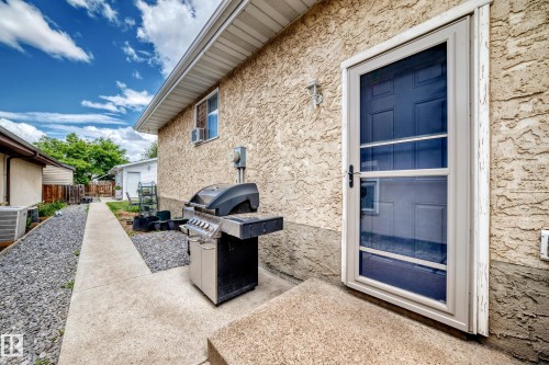 Rear exterior with stucco siding and a concrete patio - 5106 19 Avenue, Edmonton, AB 