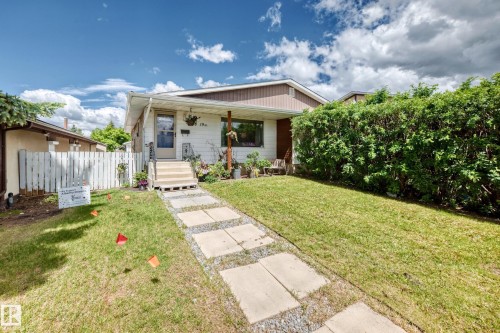 Single-story residence featuring a covered front porch with supporting columns and a partially enclosed white picket fence - 5106 19 Avenue, Edmonton, AB 