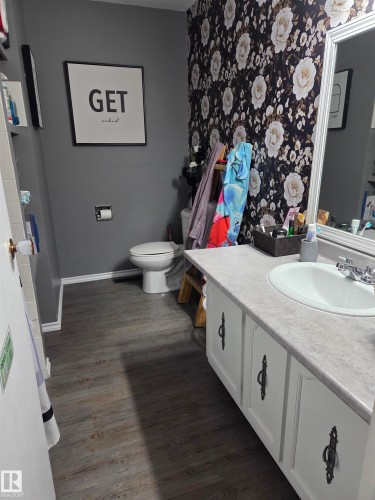 Bathroom featuring a vanity with white cabinetry, a single basin sink, and a gray countertop - 5106 19 Avenue, Edmonton, AB 