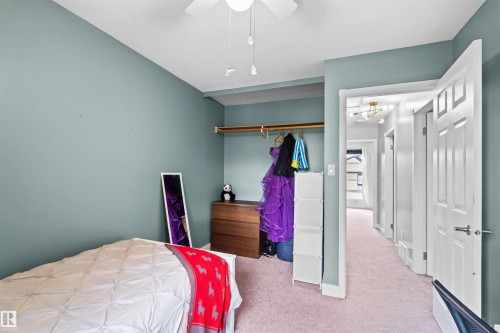 Bedroom with a built-in closet featuring a hanging rod - 12128 25 Avenue, Edmonton, AB - Indoor Photo Showing Bedroom