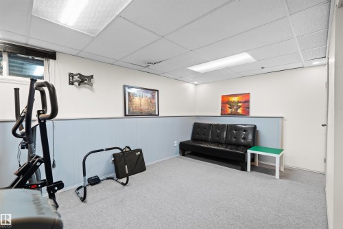 Flexible finished space featuring light gray carpeting, a window, and recessed lighting - 12128 25 Avenue, Edmonton, AB - Indoor