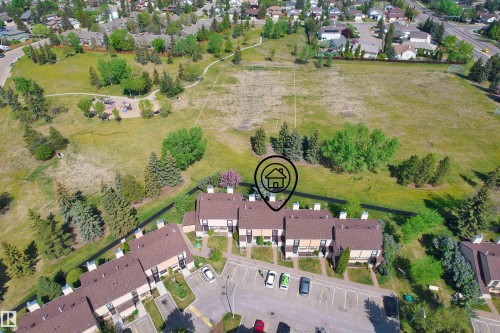 Townhome property situated by a large green space featuring walking paths, mature trees, and a playground - 12128 25 Avenue, Edmonton, AB - Outdoor With View
