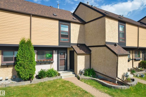Exterior townhouse featuring a brown shingle roof, tan horizontal siding, and stucco finishes - 12128 25 Avenue, Edmonton, AB - Outdoor