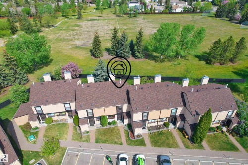 Row of townhomes featuring brown shingle roofing and light-colored siding - 12128 25 Avenue, Edmonton, AB - Outdoor With View