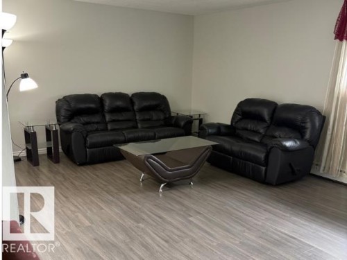 Open living area featuring wood-finish flooring and neutral wall tones - 107 10023 164St, Edmonton, AB 
