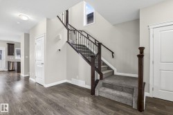 Staircase featuring dark wood newel posts and handrails with black metal balusters - 