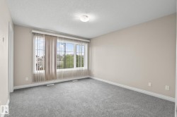 Spacious room featuring neutral carpeting, light-toned wall paint, and white trim - 