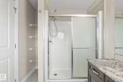 Shower with sliding frosted glass doors, chrome fixtures, and white acrylic surround - 