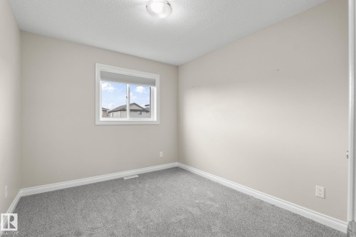 Neutral toned room featuring a single window and plush gray carpeting - 6927 Cardinal Wynd, Edmonton, AB 