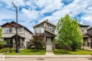 Two-story home with a stone and siding exterior, featuring a covered front porch, an asymmetrical roofline, and a manicured front lawn - 6927 Cardinal Wynd, Edmonton, AB 