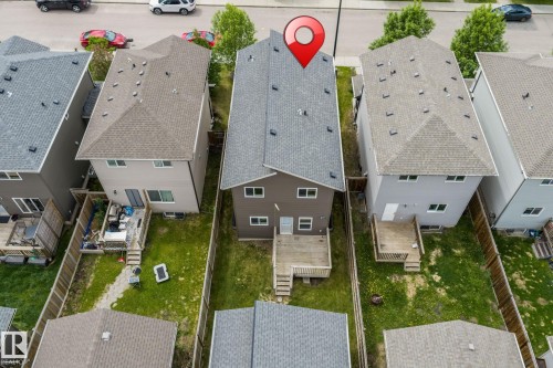 Rear elevation featuring a private fenced yard, wood deck, and upper-level windows - 6927 Cardinal Wynd, Edmonton, AB 
