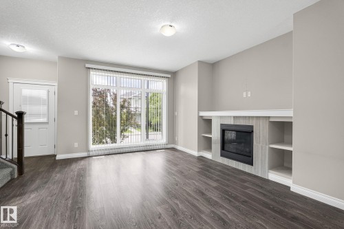 Open-concept living space with dark wood-finish flooring - 6927 Cardinal Wynd, Edmonton, AB 