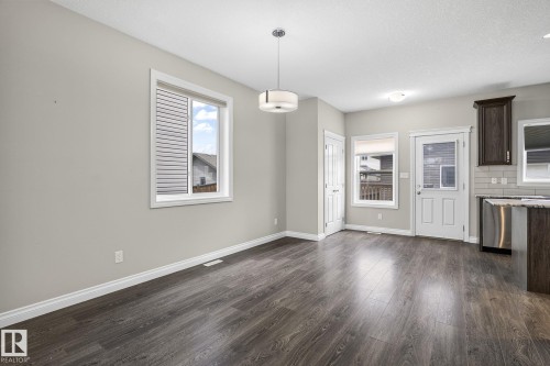Spacious room with dark wood-finish flooring, light grey walls, and white trim - 6927 Cardinal Wynd, Edmonton, AB 