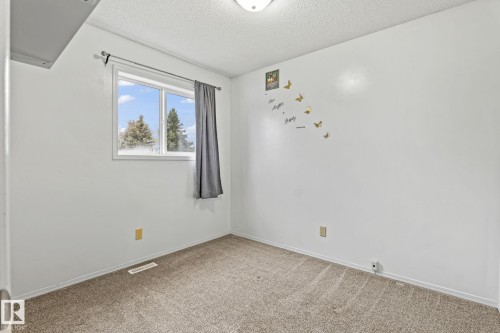 Bright room featuring white walls, a double-pane window, and textured carpeting - 128 Brookview Wy, Stony Plain, AB 