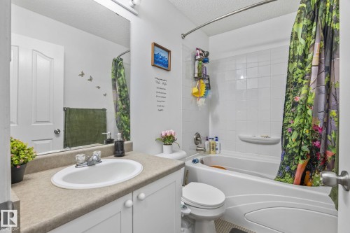 Full bathroom featuring a single vanity with a laminate countertop, an integrated sink, and white cabinetry - 128 Brookview Wy, Stony Plain, AB 