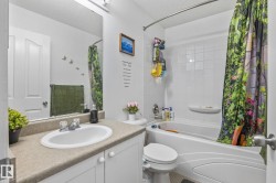 Full bathroom featuring a single vanity with a laminate countertop, an integrated sink, and white cabinetry - 