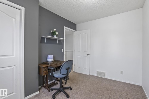 Interior room featuring white painted walls and a contrasting accent wall in a dark gray finish - 128 Brookview Wy, Stony Plain, AB 