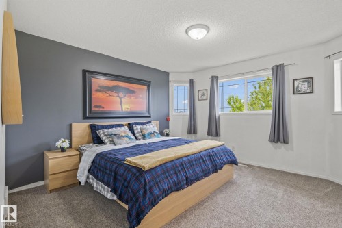 Bedroom featuring light gray carpeting, a textured ceiling, and a flush-mount ceiling light - 128 Brookview Wy, Stony Plain, AB 