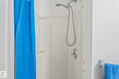 Single-piece shower enclosure with integrated shelving and chrome fixtures - 128 Brookview Wy, Stony Plain, AB 