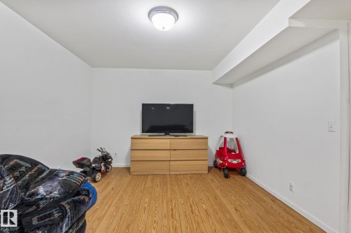 Versatile room featuring wood-finish flooring, white painted walls, and a flush mount ceiling light fixture - 128 Brookview Wy, Stony Plain, AB 