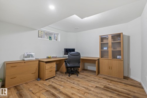 Spacious room featuring wood-finish flooring, white walls, and recessed lighting - 128 Brookview Wy, Stony Plain, AB 