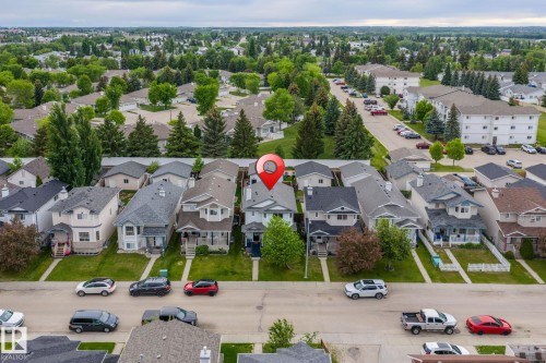Property featuring a light-colored exterior, an attached front porch, and a dark shingle roof - 128 Brookview Wy, Stony Plain, AB 