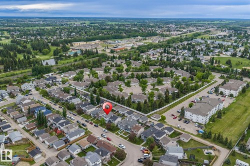 Aerial perspective showcasing a residential neighborhood with green spaces and infrastructure - 128 Brookview Wy, Stony Plain, AB 