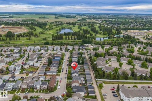 Aerial perspective showcasing a residential neighborhood with tree-lined streets and established homes - 128 Brookview Wy, Stony Plain, AB 