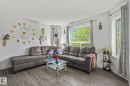 Bright living area featuring wood-finish flooring and multiple windows - 128 Brookview Wy, Stony Plain, AB 