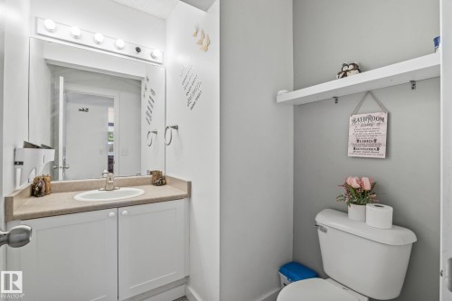Bathroom vanity featuring a white cabinet, a built-in sink, and a light-colored countertop - 128 Brookview Wy, Stony Plain, AB 