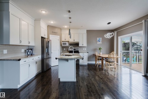 Kitchen and dining area featuring dark wood-finish flooring - 21223 58 Avenue, Edmonton, AB 