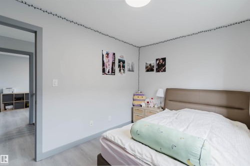 Room featuring light gray walls, matching baseboards, and wood-finish flooring - 21223 58 Avenue, Edmonton, AB 