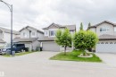 Two-story residence featuring a gray exterior with contrasting brown siding accents - 21223 58 Avenue, Edmonton, AB 