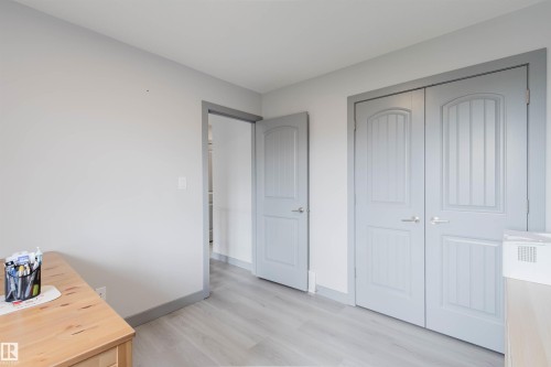 Light wood-finish flooring complements the neutral wall color - 21223 58 Avenue, Edmonton, AB 
