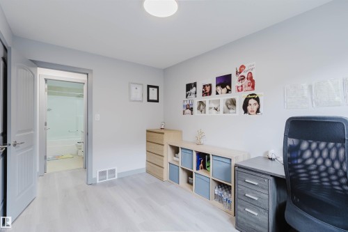 Room featuring light gray walls, wood-finish flooring, and a flush-mount ceiling light - 21223 58 Avenue, Edmonton, AB 