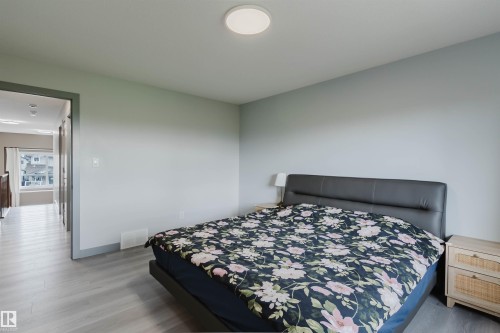 Spacious room featuring light wood-finish flooring and a neutral color palette - 21223 58 Avenue, Edmonton, AB 