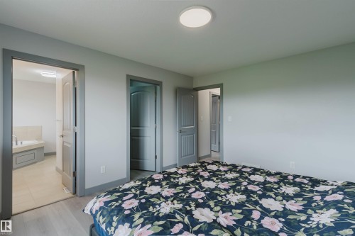 Light gray walls with contrasting dark gray trim, wood-finish flooring, and a flush-mount ceiling light fixture - 21223 58 Avenue, Edmonton, AB 