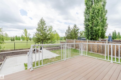Spacious wood-finish composite deck with white railings and clear panels - 21223 58 Avenue, Edmonton, AB 