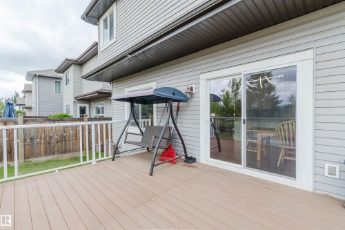 Expansive outdoor deck featuring wood-finish composite decking and white railing - 21223 58 Avenue, Edmonton, AB 