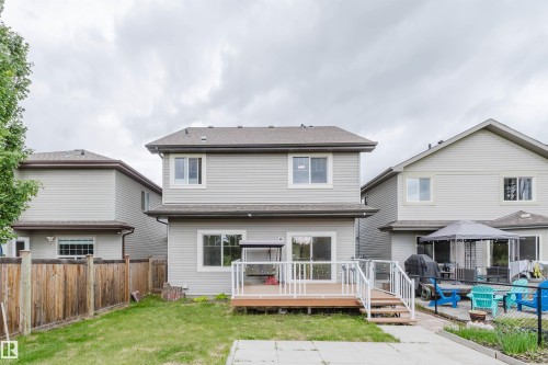 Rear exterior featuring light gray siding, a brown shingled roof, and white-framed windows - 21223 58 Avenue, Edmonton, AB 