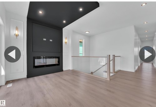 Modern linear fireplace framed by a dark accent wall with recessed lighting - 13140 187 Avenue, Edmonton, AB 