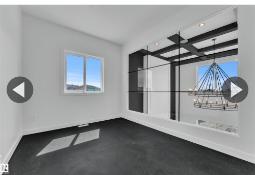 Bright room featuring dark flooring, white walls, and a large window - 13140 187 Avenue, Edmonton, AB 