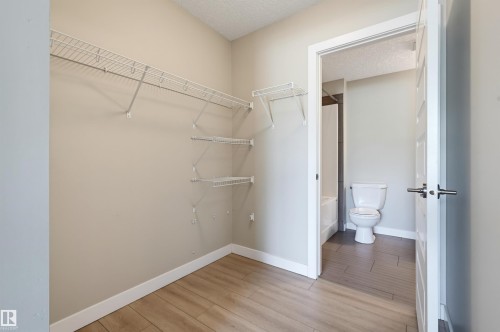 Walk-in closet with wire shelving system and wood-finish flooring - 115 1238 Windermere Way, Edmonton, AB 