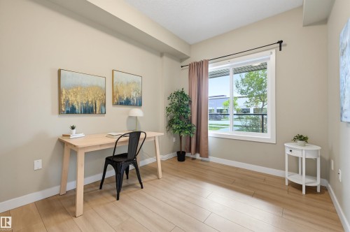 Bright interior space featuring light-toned wood-finish flooring, neutral wall paint, and white trim - 115 1238 Windermere Way, Edmonton, AB 