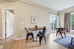 Hardwood-finish flooring throughout, featuring a sliding glass door to an exterior space, and a large window providing abundant natural light - 