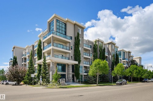 Contemporary multi-story building featuring extensive glazing, stone accents, and glass-paneled balconies - 115 1238 Windermere Way, Edmonton, AB 