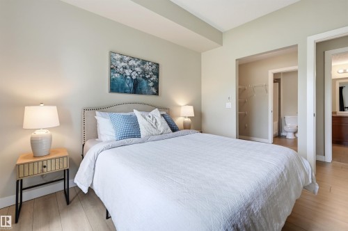 Bedroom featuring light wood-finish flooring, light neutral-toned walls, and a recessed ceiling element - 115 1238 Windermere Way, Edmonton, AB 